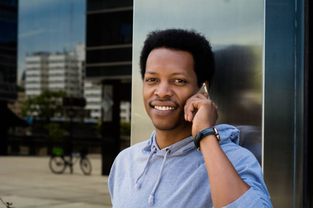istock Young latin man talking on mobile phone outside. 1127660420