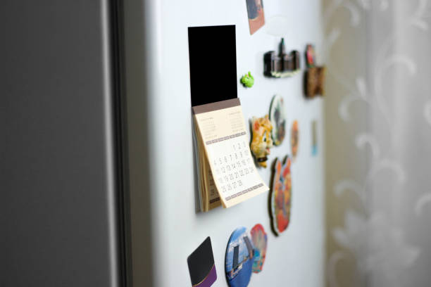 le calendrier collé sur le frigo. gros plan - magnet photos et images de collection
