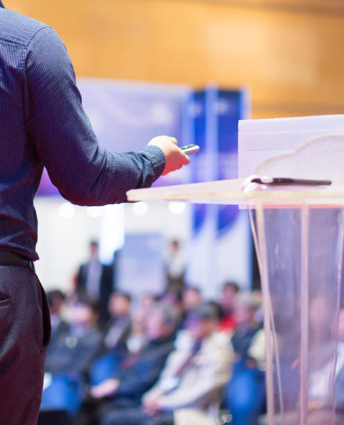 istock Speaker at Talk in Business Conference. Tech Executive Entrepreneur Speaker on Stage at Conference. Presenter Giving Business Presentation at Meeting. Corporate Exhibition for Investors Event. 1127668330