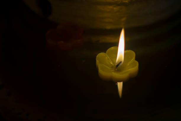 istock candlelight Candles flower floating on a water 1127680591