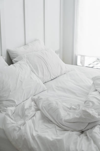 istock Cozy bedroom setting with two pillows and messy blanket and classic element install on white painted wall / modern classice style / luxury concept / interior 1127682003