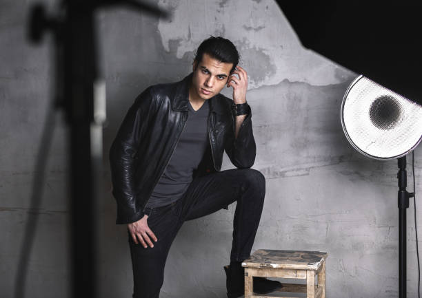 young man posing in photo Studio near wall