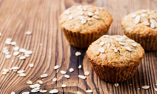 Healthy vegan oat muffins, apple and banana cakes on a wooden background. Copy space