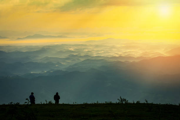 istock Successful man hiker on top mountain - Man standing on hill with sunrise 1127686223