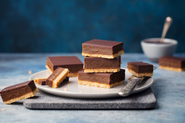 istock Chocolate caramel slices, bars, millionaires shortbread on a grey plate. Blue background. 1127686482