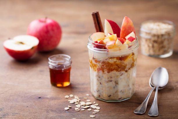 avena notturna, bircher muesli con mela, cannella e miele. sfondo in legno. - miele dolci foto e immagini stock