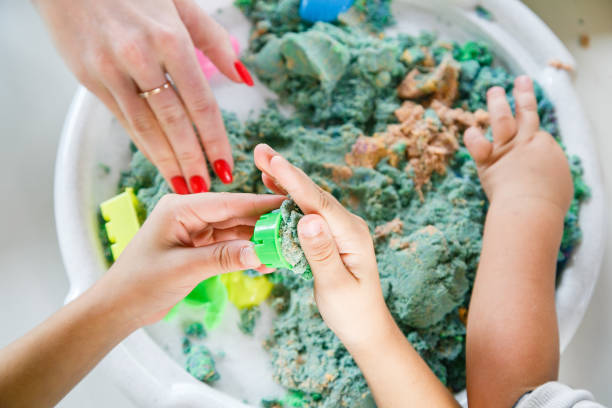 les mains d’un enfant jouant avec le sable cinétique - sandbox child human hand sand photos et images de collection
