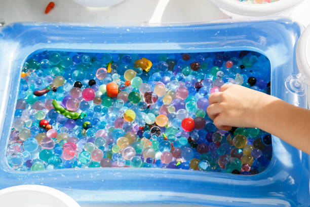 istock child playing with colored glass ball, playing game with colored balls, 1127688580