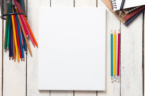 istock Empty white canvas frame and colorful pencils on whit wooden table 1127688624