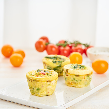 Egg muffins, paleo, keto diet. Omelet with spinach, vegetables, tomatoes baked in small molds, side view