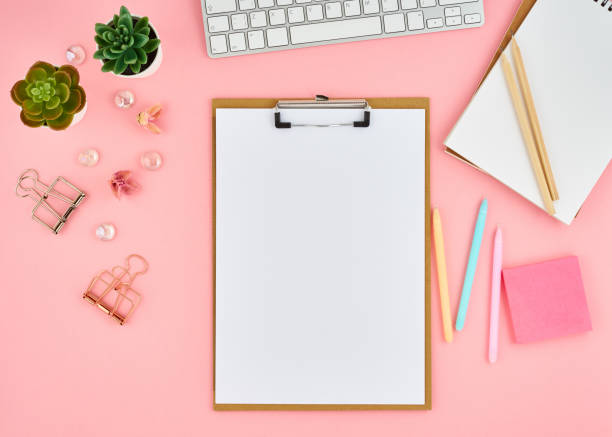 istock Blank notepad page for text on pink office desktop. Top view of modern bright table with notebook, keyboard. Mock up, copy space 1127690408
