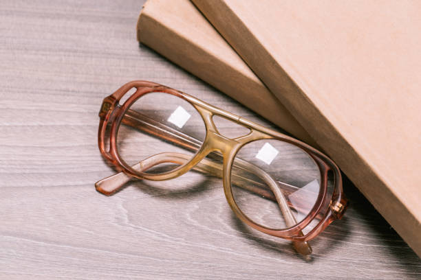 istock old book open on a wooden table with glasses 1127693688