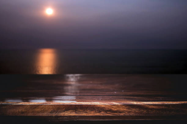 istock Old wooden table with seascape and sunset in evening 1127696820