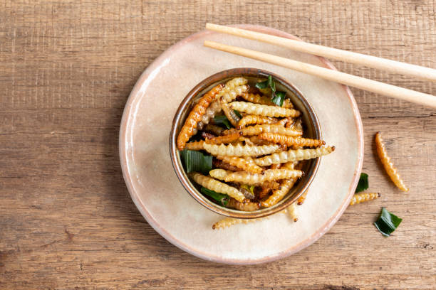 istock Bamboo edible worm insects crispy or Bamboo Caterpillar in a ceramic bowl on a wood table. The concept of protein food sources from insects. It is a good source of protein, vitamin, and fiber. 1127700238