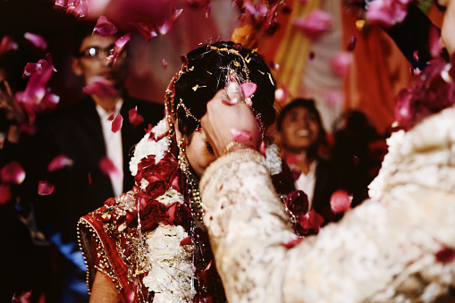 The bride and groom at the Indian wedding garlands or Jaimala ceremony on the stage.