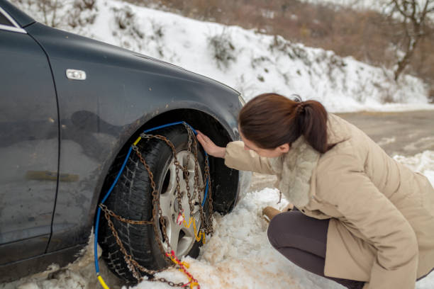 istock Beautiful woman installing snow chain on her car 1127702766