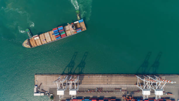istock Aerial top view container ship at sea port and working crane bridge loading container for logistic, import export, shipping or transportation. 1127705241