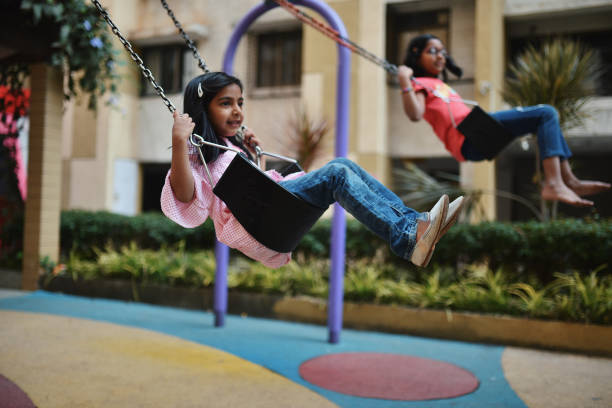 istock Two girls playing swing in the park 1127705352