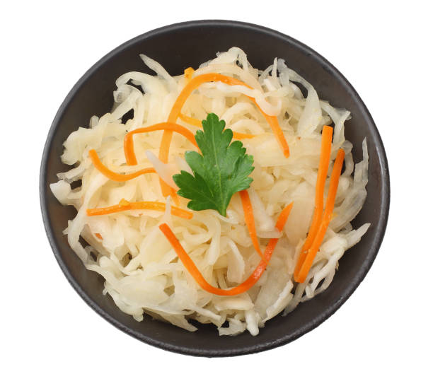 istock pickled cabbage and carrots in black plate isolated on white background. top view 1127705427