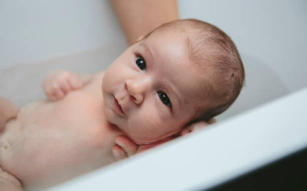 istock Newborn in the bathtub held by her mother 1127706358