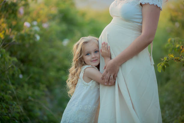 happy pregnant woman with little daughter in a green tea rose garden - barley grass field green imagens e fotografias de stock