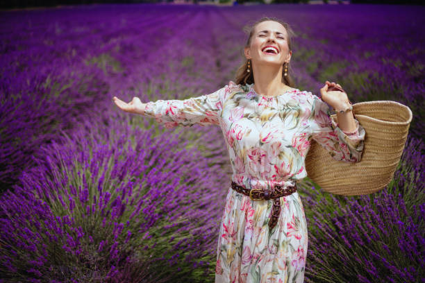 istock woman at lavender field with straw bag rejoicing 1127707821