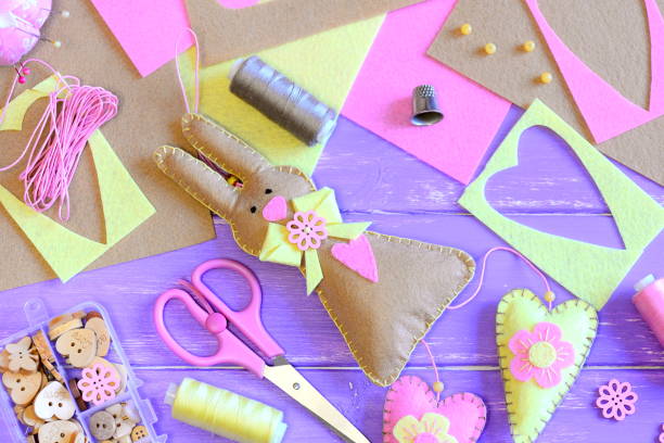 istock Cute felt Easter bunny with hearts decor. Craft supplies on a wooden background. Creative bunny wall decor. Handmade Easter crafts for children and adults to make. Top view 1127709059