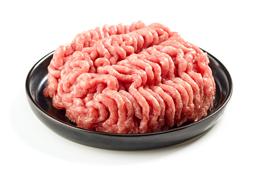 raw minced meat on black plate isolated on white background
