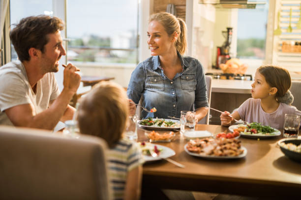 istock Happy family communicating while eating lunch at dining table. 1127713931