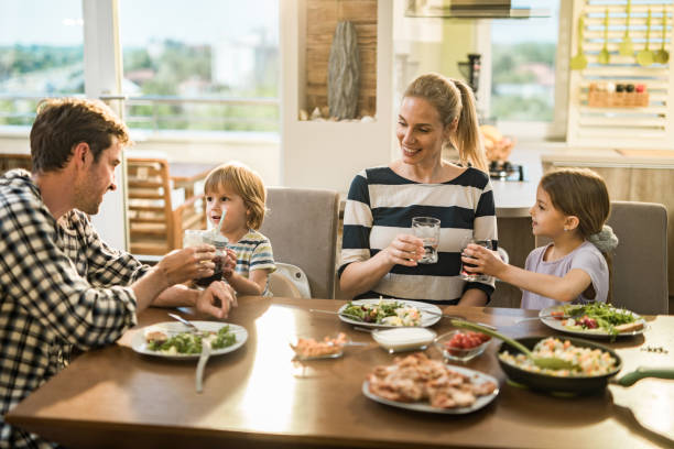 istock Happy family toasting during lunch time in dining room. 1127714013