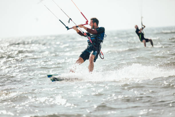 istock Athletic man riding on kite surf board 1127715315