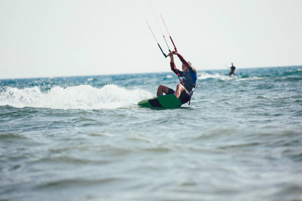 istock Athletic man riding on kite surf board 1127716694