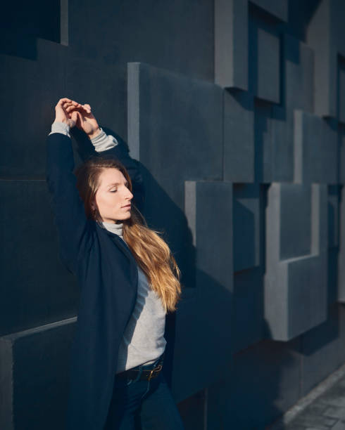 istock blond woman leaning on a dark wall 1127718850