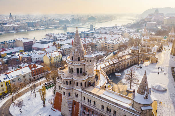 Budapest, Hungary - Aerial view of the snowy Fisherman's Bastion with Szechenyi Chain Bridge and St. Stephen's Basilica at background on a snowy winter morning stock photo