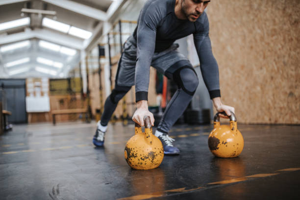 istock Athlete doing push-ups on kettle bells in gym 1127721023