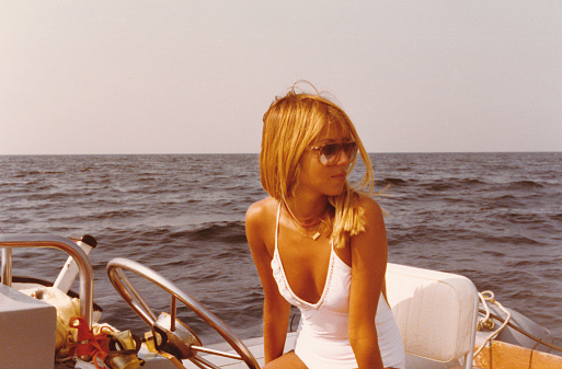 Young beautiful woman on a dinghy in 1970