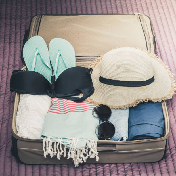 istock Open suitcase with female clothes for travel. Packing things. 1127724177