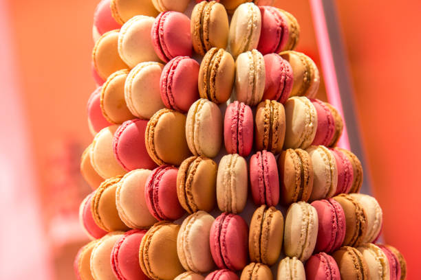 Caucasian family members cutting a birthday cake in a domestic dining room featuring a table with colorful macarons on a cake and festive decorations, creating a joyful and celebratory atmosphere.