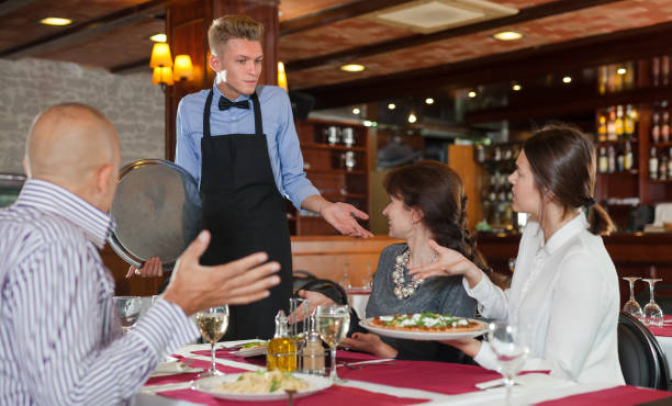 istock Dissatisfied guests with waiter 1127727564