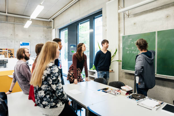 istock Students Talking With Tutor In Front Of Blackboard 1127728269