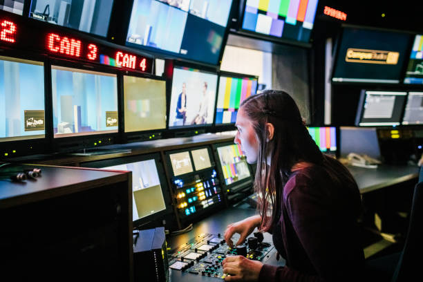 Student Using TV Studio Equipment A university student looking at various screens while using tv studio equipment. control room stock pictures, royalty-free photos & images