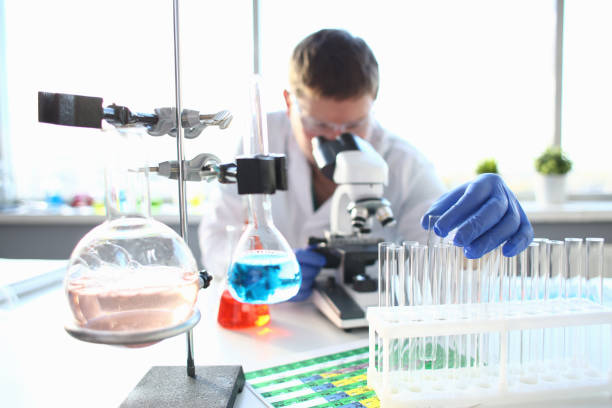 portrait of a young chemist looking in binocular - lubrication infection imagens e fotografias de stock