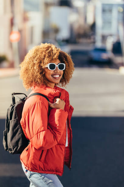 istock Cheerful woman traveller walking on street 1127730006