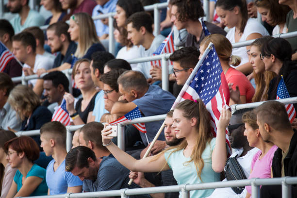 istock Spectators sitting with US Flags in stadium 1127730054