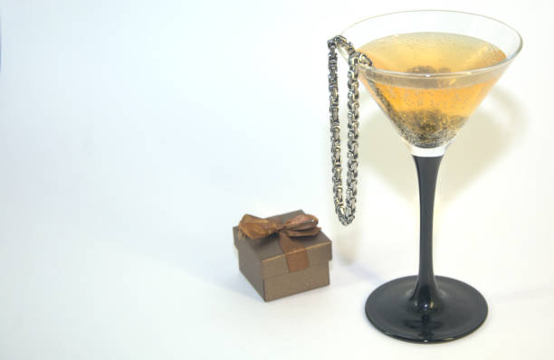 istock A glass of champagne with a chain inside and a small gift box. 1127731019