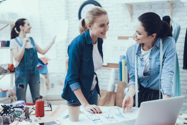 istock Girl shows on sketches and look at each other 1127732907