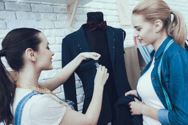 istock Women cut and looking at jacket together. 1127733049