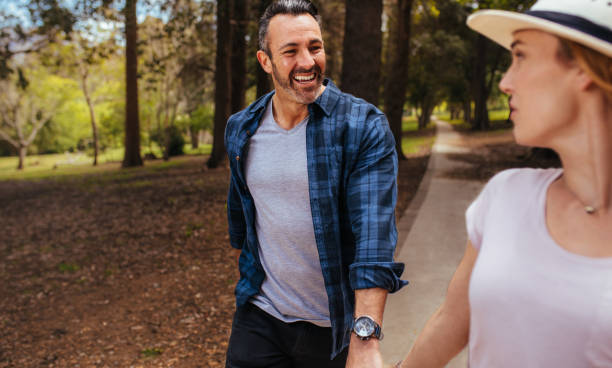 istock Happy couple walking through autumn park 1127733408