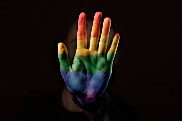 person with the rainbow flag in his or her hand - flag rainbow gay pride flag gay man imagens e fotografias de stock