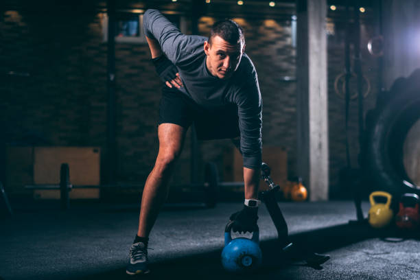 istock Young handicapped athlete with a prosthetic leg doing a one arm kettlebell swing exercise in a gym gym 1127734752